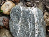 Weiße Maserung durchzieht grauen Stein